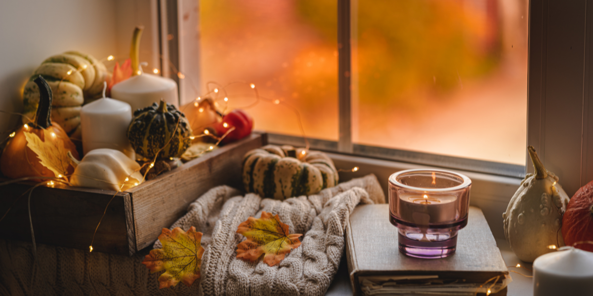 A window sil that is adorned in fall foliage and decorations.