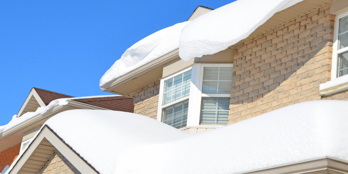 House exterior covered in a sheet of snow exposing only the windows.
