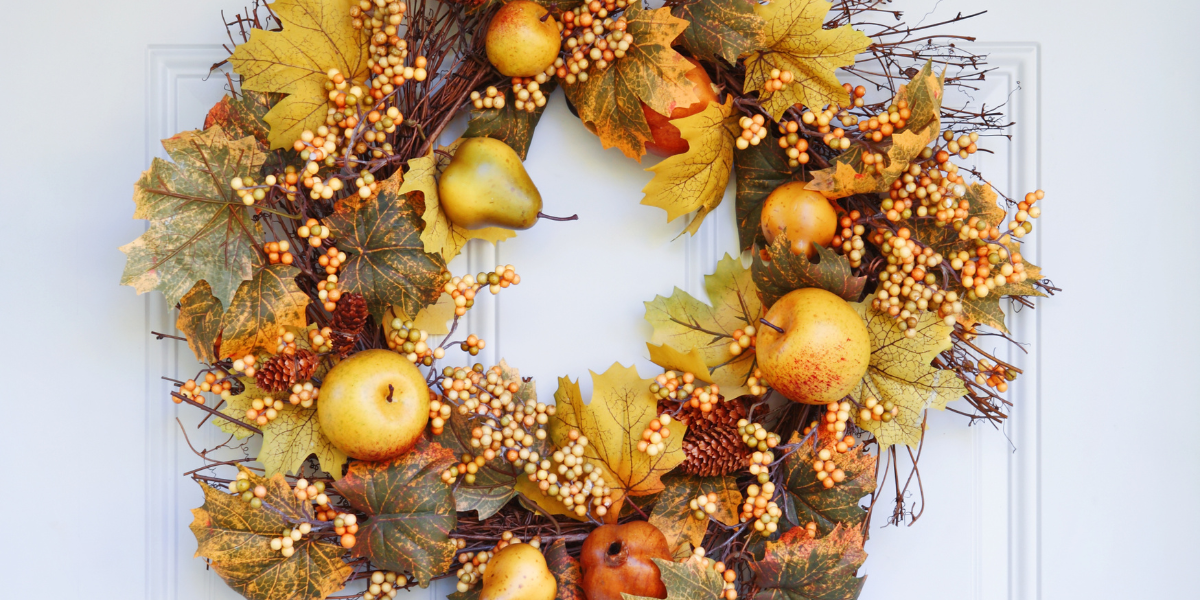 a door with a fall wreath made with fall colors and foliage 
