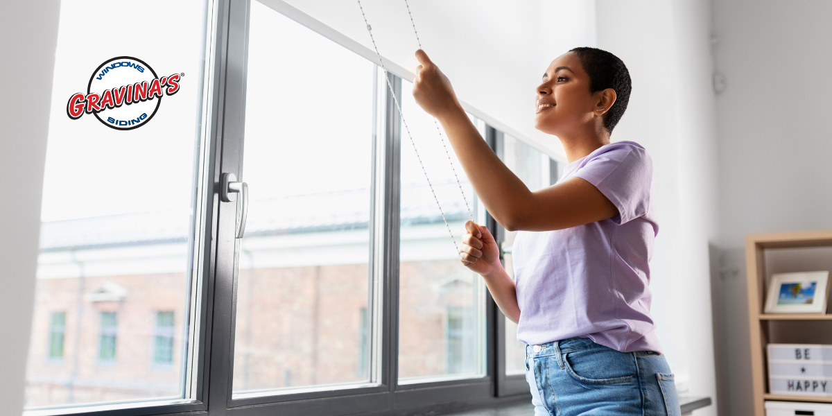 Person raising the blinds on the windows to let sunlight in.