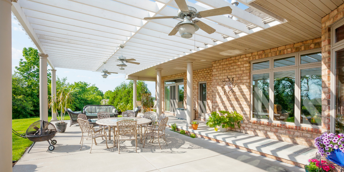 Backyard patio with outdoor fans and patio doors. 
