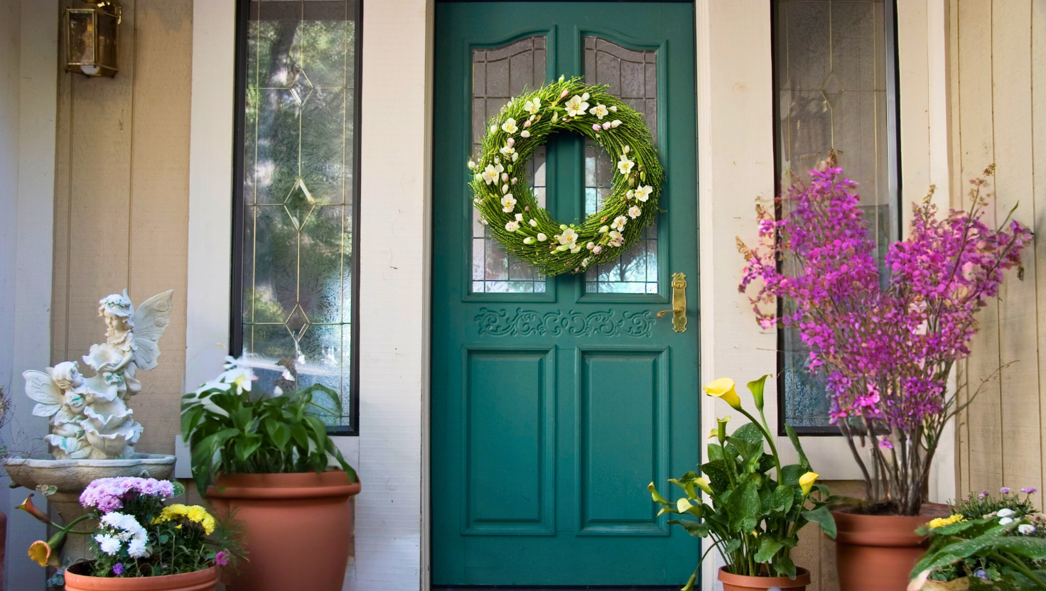 Green door that has spring plants.
