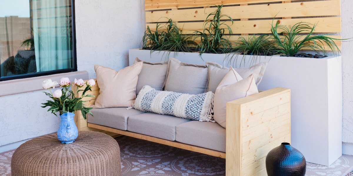 Porch furniture with colorful cushions and plants.