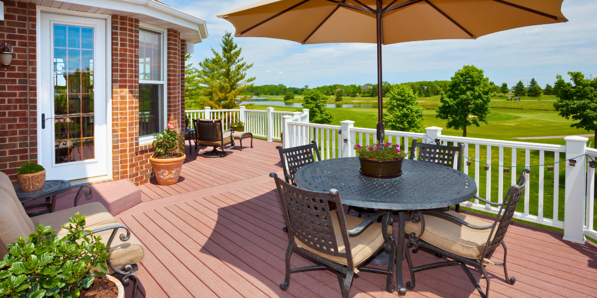 Patio deck with a table and a large umbrella.