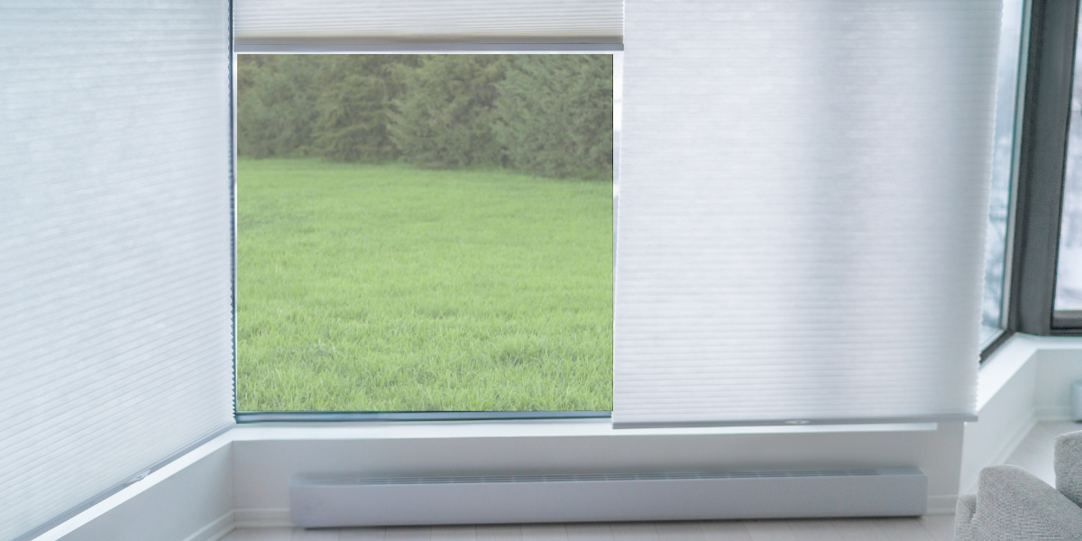 Cellular honeycomb shades on a window in a living room.