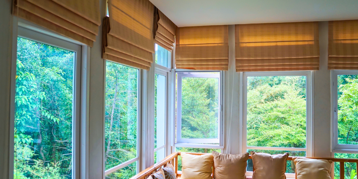 Roman shades pulled up over windows in a living room. 