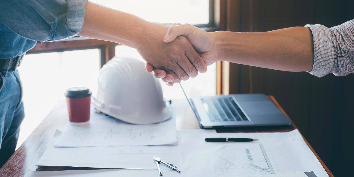 A contractor and client shake hands.