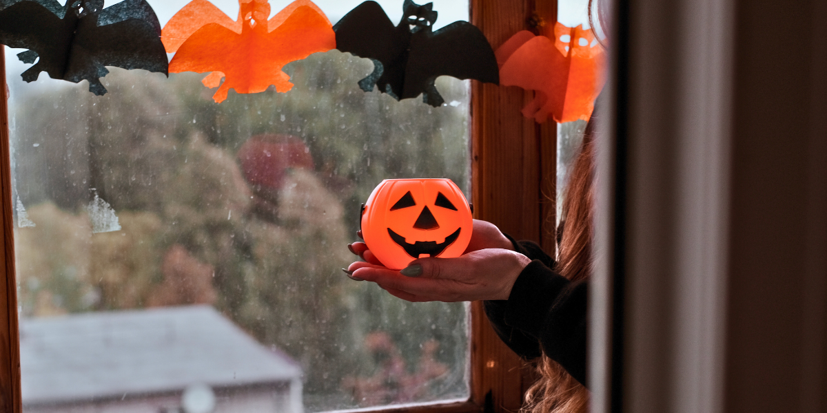 Bat and pumpkin cutouts for October decor on a window. 