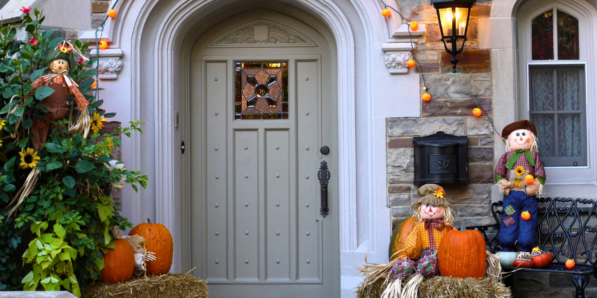 Porch decorated for fall with bales of hay. 
